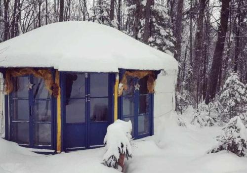 a blue building with snow on top of it at Yourte Voyageuse in Charette