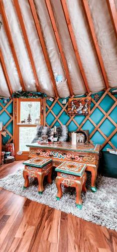 a room with a table and benches in a tent at Yourte Voyageuse in Charette