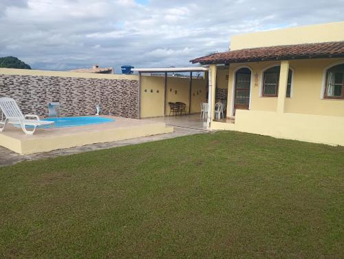 une maison avec une terrasse et une piscine dans l'établissement Bella casa de praia, à Araruama