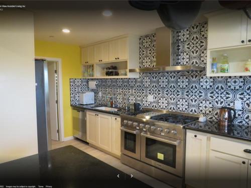 een keuken met zwarte en witte tegels op de muur bij Yellow Cactus Oasis in White Water