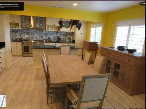 a large kitchen with a wooden table and chairs at Yellow Cactus Oasis in White Water