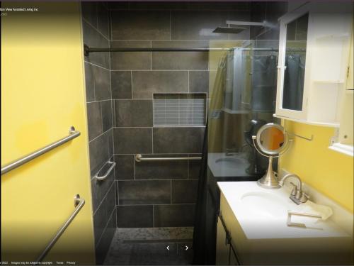 a bathroom with a shower and a sink and a mirror at Yellow Cactus Oasis in White Water
