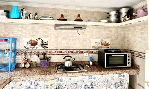 a kitchen counter with a microwave and a stove at appartement traditional cozy in Tangier