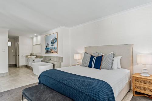 ein Schlafzimmer mit großem Bett und ein Badezimmer in der Unterkunft Sundrift - Sophisticated Beachside Retreat with Pool in Dunsborough