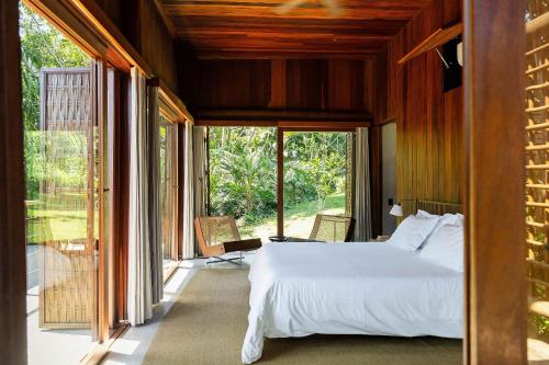 a bedroom with a bed and a large window at Villa 21 in Itacaré