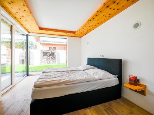 a bedroom with a bed and a large window at Alpin Chalet ARTE in Söll