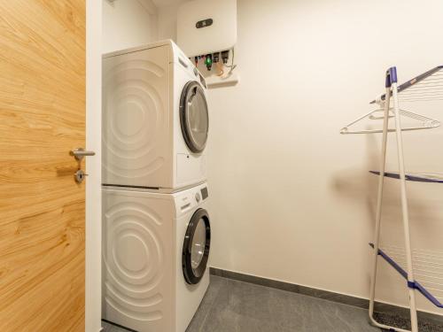 a laundry room with a washer and dryer at Grebenzen Lodge Edelweiss in Sankt Lambrecht