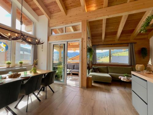 a kitchen and living room with wooden ceilings and a dining room at Grebenzen Lodge Edelweiss in Sankt Lambrecht