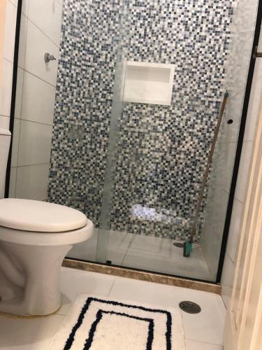 a bathroom with a glass shower with a toilet at Monte Carlo Residencial in Valença