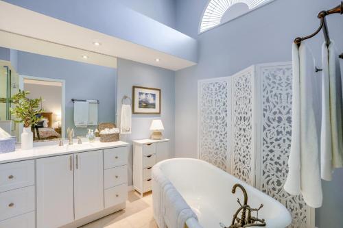 Un baño blanco con bañera y lavabo. en Fort Myers Vacation Rental with Lanai and Private Pool, en Fort Myers