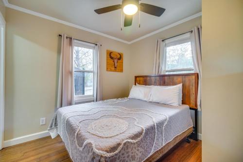 a bedroom with a bed with a ceiling fan and two windows at Lakefront Eucha Escape with Views and Boat Slip! in Eucha