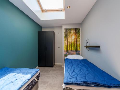 une chambre avec des murs bleus et une lucarne dans l'établissement Reggezicht, à Hellendoorn