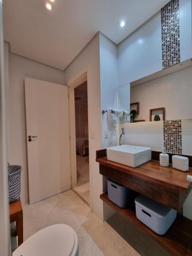 a bathroom with a toilet and a sink at AptoVistamarArtachoJuradoComRoupaCamaBanho in Santos