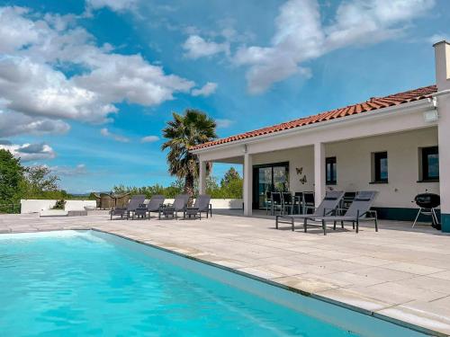 une piscine avec des chaises longues et une maison dans l'établissement Panorama, à Rieux-Minervois
