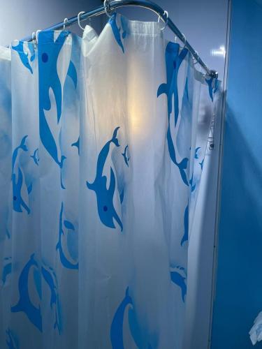a shower curtain with dolphins on it in a bathroom at Alojamiento 2 Oriente in Curacautín