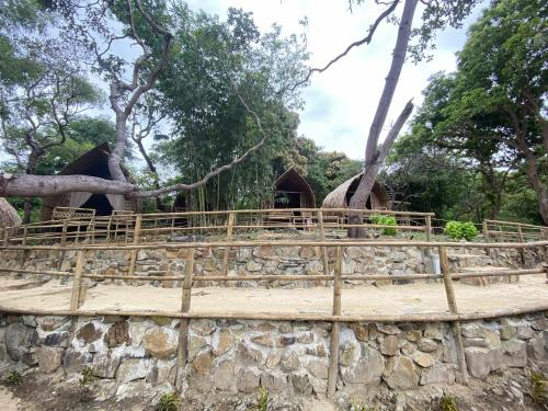 a bridge over a stone wall with a tree at MORE Beach in El Nido