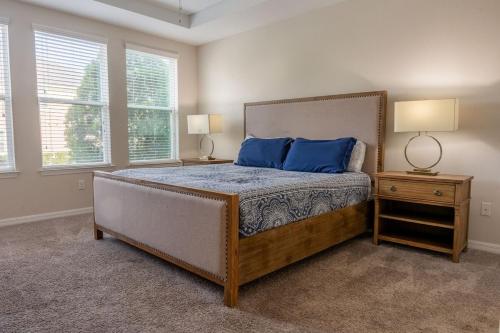 ein Schlafzimmer mit einem Bett mit blauen Kissen und zwei Lampen in der Unterkunft Luxury and Spacious Villa with Pool and Hot Tub just minutes from Disney in Kissimmee