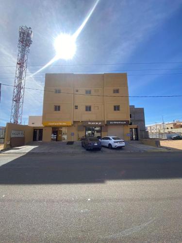 a large building with cars parked in a parking lot at ملاذ العلا in AlUla