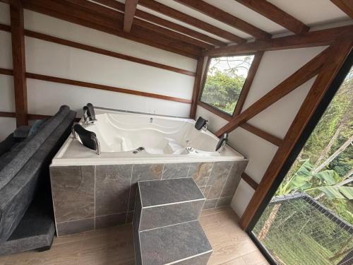eine große Badewanne in einem Raum mit Fenster in der Unterkunft Finca de Descanso El Ocaso in Sevilla