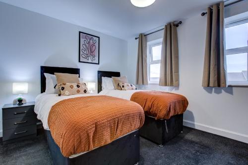 达特福德NEW! 5BR Gem by Prime Vault Properties, Town Centre Near Train Station with Driveway Parking的卧室设有两张床铺,拥有蓝色的墙壁和窗户