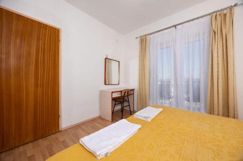a bedroom with a bed and a window and a desk at Apartment Igrane 311b in Igrane