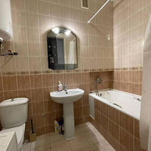 a bathroom with a sink and a toilet and a tub at Центр города 2 кв Набережная in Dnipro