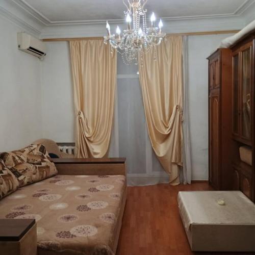 a living room with a couch and a chandelier at Центр города 2 кв Набережная in Dnipro