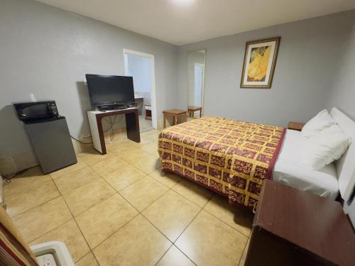 a hotel room with a bed and a television at Parklane Motel in Oakland