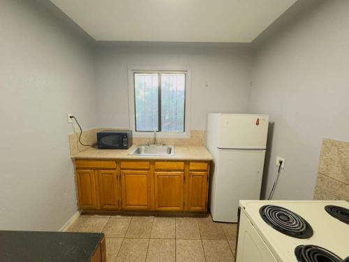 a kitchen with a sink and a white refrigerator at Parklane Motel in Oakland