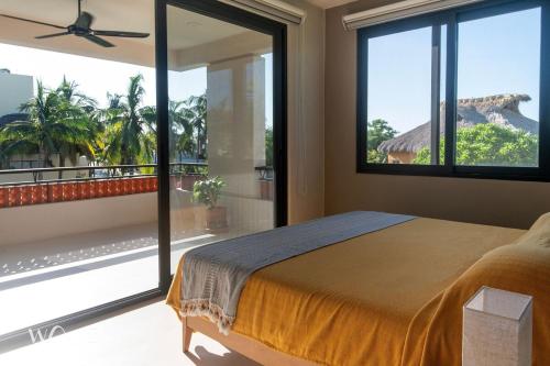 Schlafzimmer mit einem Bett und einem Balkon mit Fenstern in der Unterkunft Casa Hormiga · Refugio c/vista al mar y Alberca in Puerto Escondido