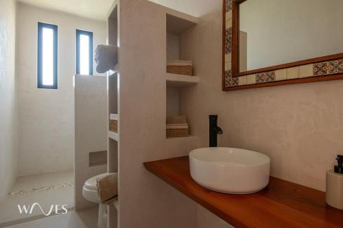 ein weißes Badezimmer mit Waschbecken und Spiegel in der Unterkunft Casa Hormiga · Refugio c/vista al mar y Alberca in Puerto Escondido