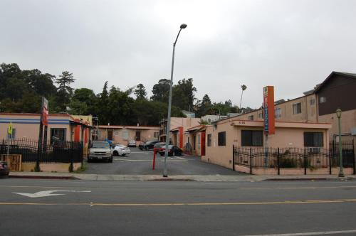 a street with cars parked in a parking lot at Parklane Motel in Oakland