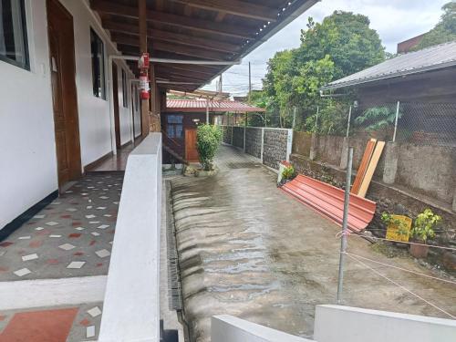 a porch of a house with a bench and a building at El Colibrí in Puyo