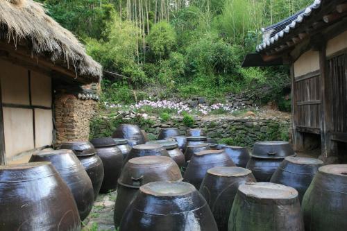 a group of large metal pots sitting next to a building at Jinrae Lee's Traditional House in Boseong