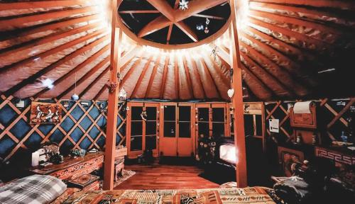 an attic room with a wooden ceiling and a large window at Yourte Voyageuse in Charette