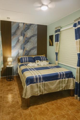 a bedroom with a bed with a painting on the wall at Ethlyn House in Bocas Town