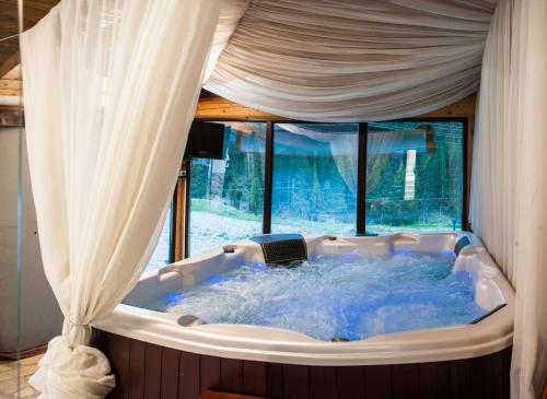a jacuzzi tub in a room with a window at Boriki Complex in Pamporovo