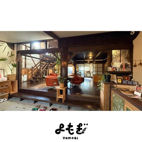 a living room with wooden floors and a room with chairs at YOMOGI GUESTHOUSE in Tokoname