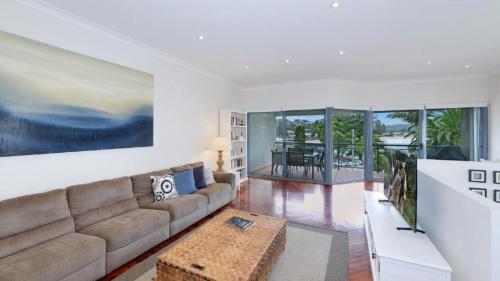 a living room with a couch and a table at The Point On Cliff - Two Levels and Views in Avoca Beach