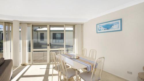 a white dining room with a table and chairs at Sandpiper 4 - Great Location in Avoca Beach