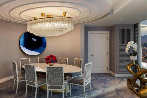 a dining room with a table and chairs and a chandelier at Fontainebleau Las Vegas, MICHELIN Key Award Hotel in Las Vegas