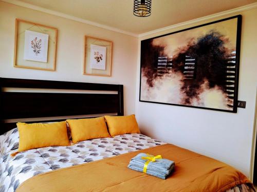 ein Schlafzimmer mit einem Bett mit orangefarbenen Kissen darauf in der Unterkunft Casa Boutique, Lujo, Seguridad y Privacidad Total in Coquimbo