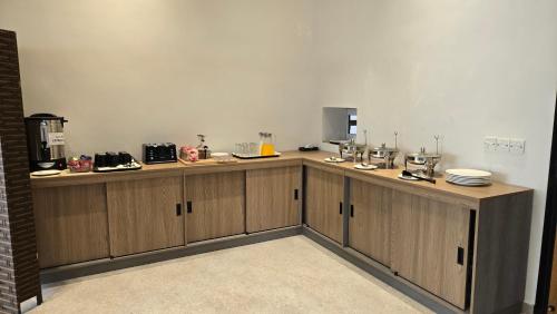 カラチにあるCentral Residence by Paramount Hospitalityの皿が置かれた木製のキャビネットを備えたキッチン