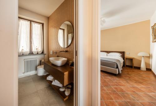 a bedroom with a bed and a sink and a mirror at Casa Nizza D'Oro in Castelnuovo