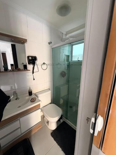 een kleine badkamer met toilet en douche bij King Midas in Guarujá