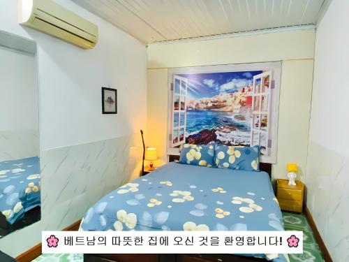 Nam Mỹ Vân Homestay - ĐH Công nghiệp Thái Nguyên في Thái Nguyên: غرفة نوم بسرير ازرق مع لوحة على الحائط