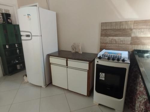 a kitchen with a refrigerator and a stove at Lumiar Garden Suítes e Chalés em Vilas do Atlântico in Lauro de Freitas