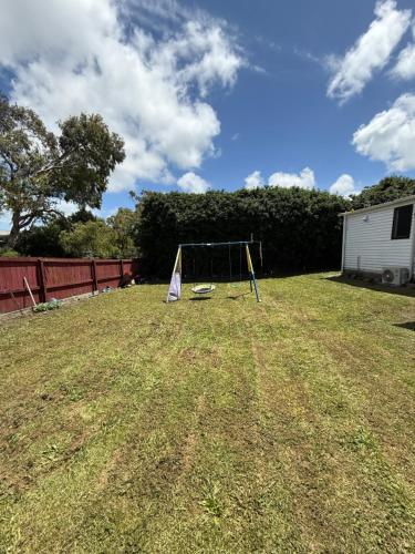 a swing set in the middle of a yard at 2-bed granny flat near Auckland Airport in Auckland