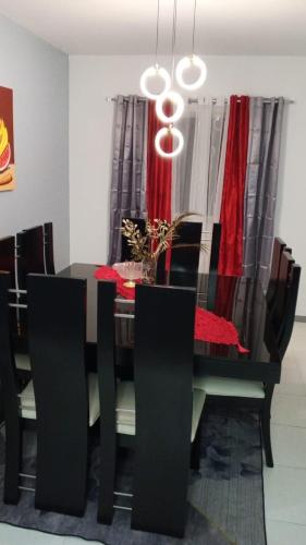 a dining room with a table and chairs with a red table cloth at Hermoso apartamento in Santo Domingo