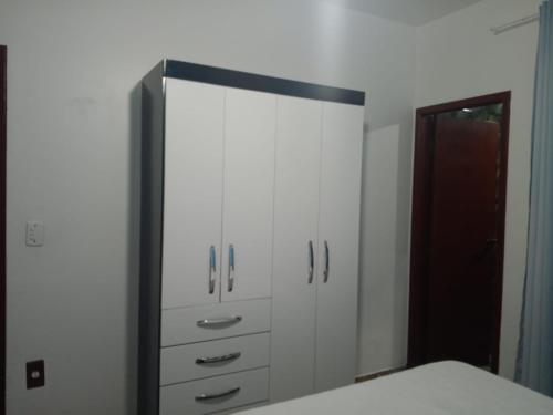 a bedroom with a large mirror and white cabinets at pousada top mix apt 202 in Florianópolis